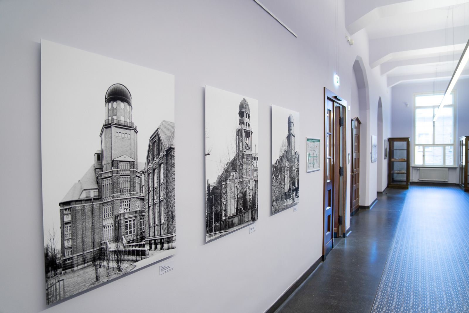 Bilder der Ausstellung Beyer-Bau hängen auf dem Gang